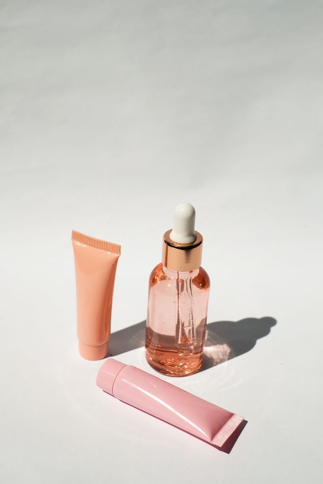 Serum Bottle and Cosmetic Tubes on White Background